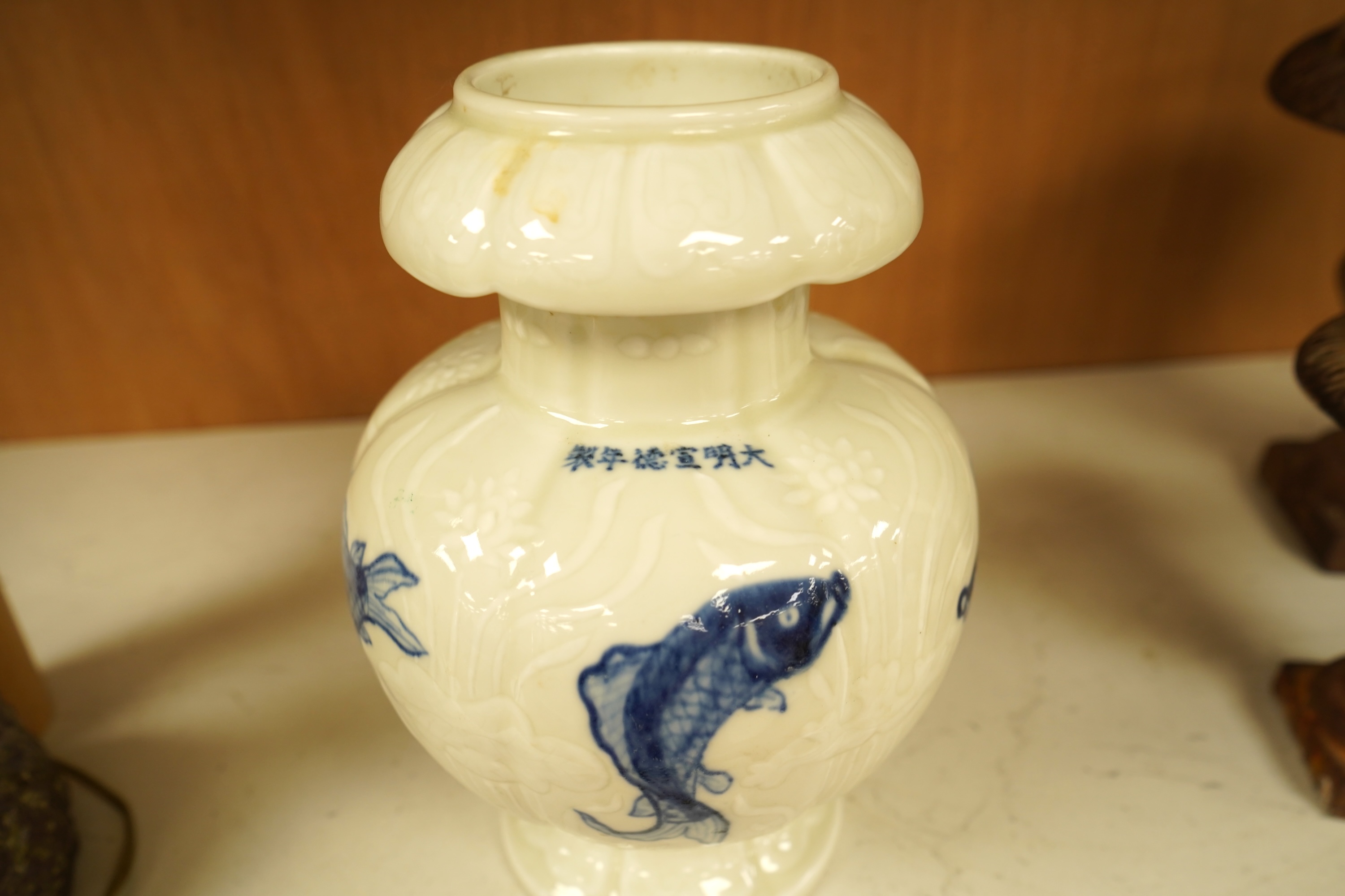 A Chinese vase decorated in low relief, hand painted with fish, 20cm high